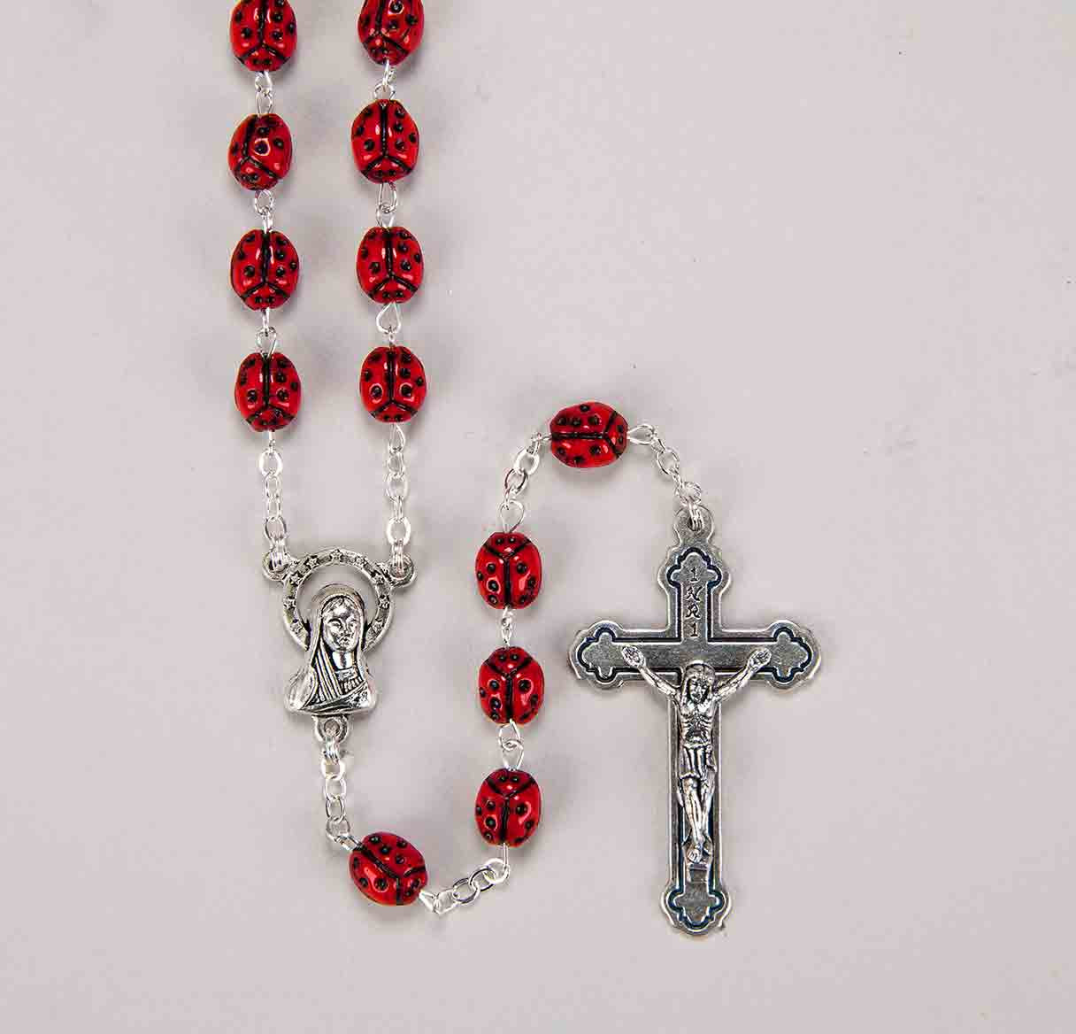 Rosary in red with prayer card with the Seven Sorrows of the Blessed Virgin Mary